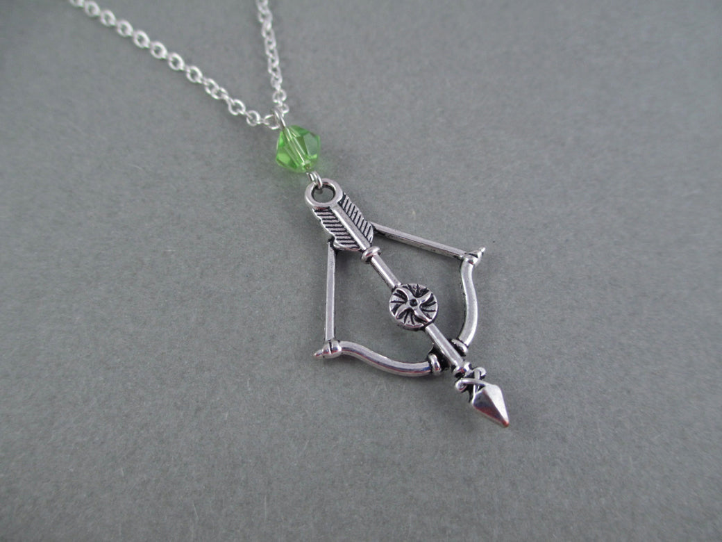 Silver colored bow and arrow charm necklace with crystal bicone bead.