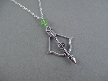 Silver colored bow and arrow charm necklace with crystal bicone bead.